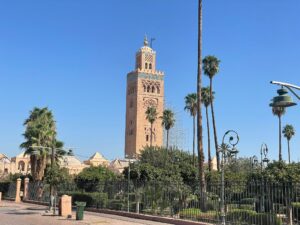 12 Days Morocco Desert Tour ,A long caravan of camels walks along the crest of the golden sand dunes of the Sahara Desert under a setting sun, during a 12-day tour from Marrakech.,A small group of travelers, wearing turbans and smiling, ride camels on a tour through the Erg Chebbi dunes on a 12-day desert expedition from Marrakech.,The ancient earthen kasbah of Ait Benhaddou, a UNESCO World Heritage site, bathed in morning light, a key stop on a 12-day Morocco tour from Marrakech to the desert.,A tourist and a local Berber guide share a pot of mint tea inside a traditional desert camp tent during a 12-day Morocco desert tour.