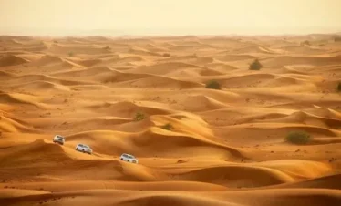 3 Days Morocco Desert Tour,A camel caravan moving across the tall, golden sand dunes of Erg Chebbi at sunset, with the High Atlas Mountains visible in the far distance.,Travelers riding camels in a single-file line during a sunset camel trek on the orange sand dunes of Merzouga.,Traditional Berber tents set up amongst the sand dunes of the Sahara desert under a starry night sky.,The historic, earthen-walled Ksar of Aït Benhaddou, a UNESCO World Heritage site, built into a hillside in southern Morocco..A winding road cutting through the rugged, reddish-brown peaks of the High Atlas Mountains in Morocco..The towering, sheer rock walls of Todra Gorge, with a narrow river and pathway at the bottom..A group of happy travelers posing together on top of a large sand dune in the Erg Chebbi desert.