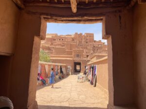 4 Days Morocco Desert Tour,A camel caravan casts long shadows as it traverses the tall, golden sand dunes of the Erg Chebbi desert at sunset, with the clear night sky beginning to emerge above..Travelers happily riding camels in a single-file line across the red sand dunes of the Sahara desert towards a traditional Berber camp.,A cluster of traditional Berber tents set against the dramatic backdrop of the Erg Chebbi sand dunes under a star-filled night sky..The sprawling, earthen-walled Ksar of Ait Ben Haddou, a UNESCO World Heritage site, built into a hillside along a river valley..The towering, sheer limestone cliffs of Todgha Gorge, with a narrow river and pathway visible at the bottom..A scenic road, the Tizi n'Tichka Pass, winding through the rugged, reddish-brown peaks of the High Atlas Mountains..A panoramic view of the vast, golden sand dunes of the Moroccan Sahara desert.