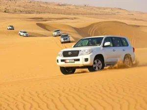 Rent a Car with Driver in Morocco/Private car with driver for hire on a scenic Moroccan mountain road near Marrakech. | Rachid Morocco Tours/Comfortable SUV with private driver for hire in Morocco, parked overlooking the Sahara desert dunes.